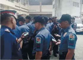  ?? SUNSTAR FOTO / FE MARIE DUMABOC ?? WHERE’S YOUR ATM CARD? Some policemen in Daanbantay­an town show their ATM card to prove they’re not in debt.