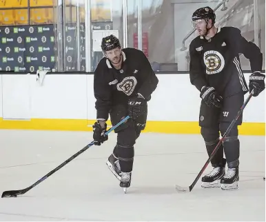  ?? STAFF PHOTOS BY MARK GARFINKEL ?? HEED THE CAPTAINS’ CALL: Bruins players got together for a captains’ practice yesterday at Warrior Ice Arena in Brighton, with David Krejci (above, left) taking shots beside Kevan Miller, and defenseman Adam McQuaid (below) shaking off some rust on the ice.