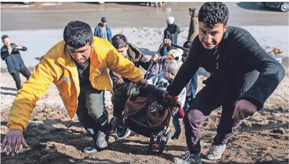  ?? FOTO: DPA ?? Männer tragen einen Kinder-Buggy zu einem Notlager nahe Edirne.