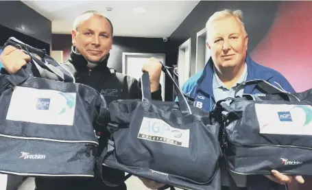  ??  ?? Paul Mullaney, owner of AGP Decorators, hands over the first of the team kit bags to Keith Bell.