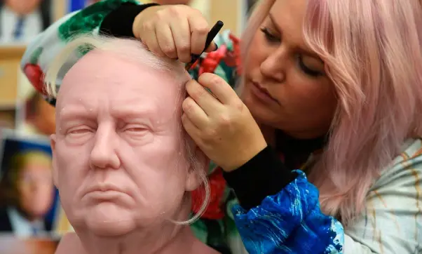  ??  ?? COMB OVER: A sculptor inserts yak hairs onto the wax figure of the US President-elect at Madame Tussauds in west London. Photo: Charlotte Ball/AP