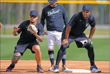  ?? Associated Press ?? Drills: Detroit Tigers infielders Javier Baez, left, and Jonathan Schoop, right, work on drills at second base during a spring training baseball workout Sunday in Lakeland, Fla.