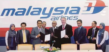 ?? PIC BY EIZAIRI SHAMSUDIN ?? Malaysia Airlines Bhd chief executive officer (CEO) Peter Bellew (sixth from left) exchanging documents with ATS Global Travel CEO Azize Othman (third from left) at the signing ceremony in Kelana Jaya yesterday.