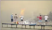  ?? EMRE TAZEGUL — THE ASSOCIATED PRESS ?? Tourists wait to be evacuated from the smoke-engulfed Mazi area as wildfires rolled down the hill toward the seashore in Bodrum, Mugla, Turkey, on Sunday.