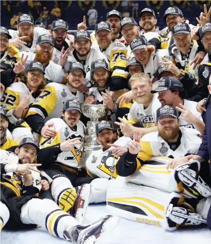  ??  ?? The Pittsburgh Penguins celebrate with the Stanley Cup Trophy after they defeated the Nashville Predators 2-0 in Game 6 of the 2017 NHL Stanley Cup Final at the Bridgeston­e Arena in Nashville, Tennessee, on Sunday night. (AFP)