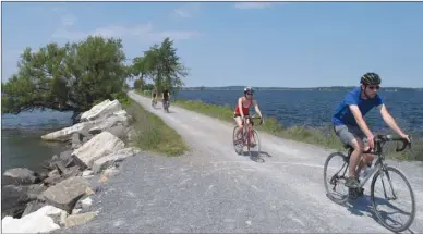  ?? The Associated Press ?? In this photo taken in Colchester, Vt., bicyclists ride on the Island Line Trail bike path on an abandoned railroad causeway from the Vermont mainland to the Lake Champlain islands. The seasonal ferry on the 4.8-kilometre section of the Island Line...