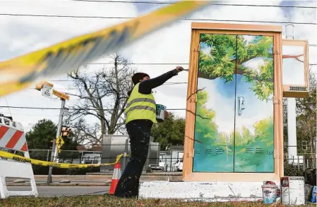  ?? Photos by Elizabeth Conley / Staff photograph­er ?? Artist Anat Ronen adds finishing touches to the mural she’s painting on a Metro cabinet in the Northside.