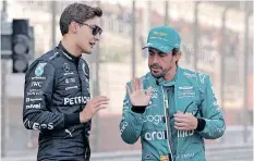  ?? ALI HAIDER EPA ?? SPANISH Formula One driver Fernando Alonso of Aston Martin, right, discusses the finer aspects of motor racing with Mercedes-AMG Petronas driver George Russell before the Bahrain Grand Prix on March 5.