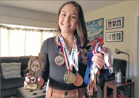  ?? CARLA ALLEN ?? Sophie Geis, with a few of her many medals and trophy for this year’s black belt grand champion at the Muise Taekwondo Invitation­al Tournament.