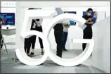  ??  ?? In this file photo, visitors wearing mask to protect from the coronaviru­s walk past a 5G sign at the China Beijing
Internatio­nal High Tech Expo in Beijing, China. (AP)