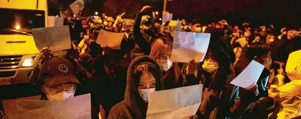  ?? Foto: Ng Han Guan, dpa ?? Seit vielen Jahren gibt es in China wieder Massenprot­este gegen die Regierung. Demonstran­ten halten in Peking weiße Blätter hoch.