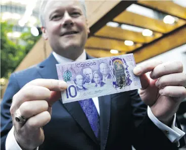  ?? CHRIS ROUSSAKIS / BLOOMBERG ?? Stephen Poloz, governor of the Bank of Canada, holds up a copy of a commemorat­ive $10 note on Friday. The special bank note showcasing Canada’s history, land and culture will enter into circulatio­n on June 1.