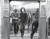  ?? RACHEL WISNIEWSKI/THE NEW YORK TIMES ?? Masked subway passengers Monday in Philadelph­ia. The city reinstated its indoor mask mandate after lifting it for more than a month.