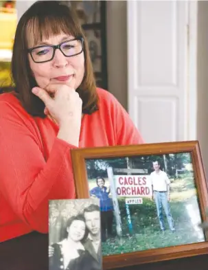  ?? STAFF PHOTO BY DOUG STRICKLAND ?? Pictures of Kathy Shelby’s parents, Carmie and William Cagle, are displayed on a table as Shelby talks Thursday about her family’s history of cancer in the dining room of her home in Chattanoog­a. Shelby and many of her family members have been...