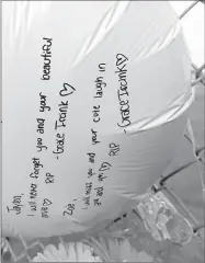  ??  ?? A balloon with written messages to both school shooter Jaylen R. Fryberg, 15, and Zoe R. Galasso, 14, one of his victims, rests sideways as part of a growing memorial Monday at Marysville Pilchuck High School in Marysville, Wash.