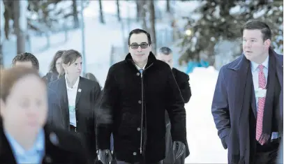  ?? Markus Schreiber ?? The Associated Press Secretary of the Treasury Steven Mnuchin walks through the snow Wednesday during the annual meeting of the World Economic Forum in Davos, Switzerlan­d. He arrived ahead of President Donald Trump, who is set to address the forum...