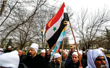  ??  ?? Druze men and youths wave Syrian (top) and Druze (bottom) flags during a protest against Trump’s recognitio­n of Israel’s annexation of the territory, in the Druze village of Buqata in the Israeli-annexed Golan Heights. — AFP photo