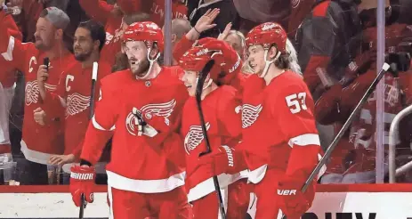  ?? DUANE BURLESON/AP ?? Red Wings left wing Lucas Raymond, center, celebrates with center Michael Rasmussen, left, and defenseman Moritz Seider, right, after scoring against the Capitals during the first period Tuesday at Little Caesars Arena.