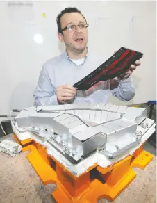  ??  ?? Boris Novakovic of SPM Automation Canada Inc. shows a high-temperatur­e, non-contact hot plate used for welding automobile tail lights on Tuesday.