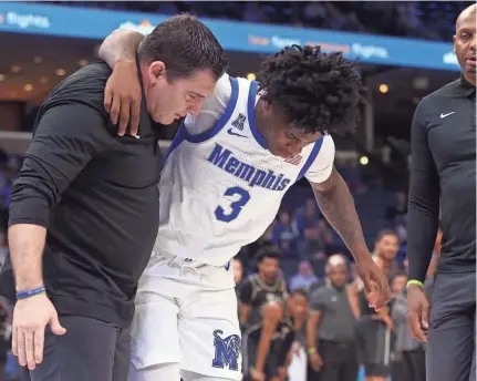  ?? PETRE THOMAS/USA TODAY SPORTS ?? Memphis guard Kendric Davis is helped off the floor by a trainer after an injury during the first half against UCF on Thursday at Fedexforum.