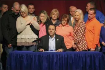  ?? ROBERT RAY - THE ASSOCIATED PRESS ?? The parents of the deceased 15 year old Bailey Holt, left, stand in tears as Kentucky Gov. Matt Bevin signs the prayer proclamati­on on Friday, Jan. 26, 2018 in Benton, Ky. Marshall County High School reopened its doors Friday as the school day began...