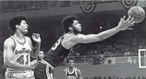  ?? JOURNAL SENTINEL FILES ?? Lew Alcindor reaches for a loose ball as Baltimore Bullets star Wes Unseld can only watch in a dominating performanc­e by the Bucks in Game 4 of the NBA Finals on April 30, 1971.