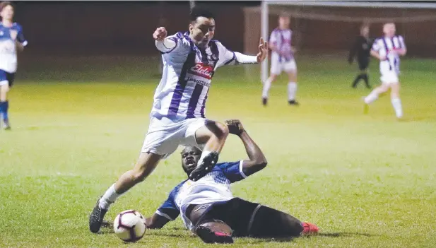  ?? Picture: BRENDAN RADKE ?? RISING: Comets' Elton Bozkurt leaps over a lunging Marlin Coast defender Jacob Lahai during their FNQ Premier League match.