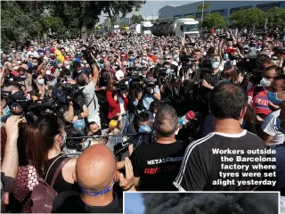  ?? Pictures: REUTERS, AFP ?? Workers outside the Barcelona factory where tyres were set alight yesterday