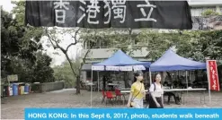  ??  ?? HONG KONG: In this Sept 6, 2017, photo, students walk beneath a black banner reading “Hong Kong Independen­ce” which is displayed at the Chinese University of Hong Kong campus. — AP