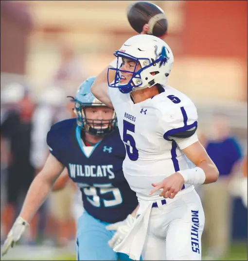  ?? NWA Democrat-Gazette File Photo/ANDY SHUPE ?? Rogers quarterbac­k Hunter Loyd (right) passes while under pressure from Har-Ber defensive end Blake Wade on Sept. 22 at Wildcat Stadium in Springdale. Both players return for their respective teams this season.