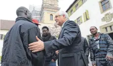  ?? FOTO: DPA ?? Gebhard Fürst, Bischof der Diözese Rottenburg-Stuttgart, begrüßt im April 2014 eine Gruppe von afrikanisc­hen Flüchtling­en vor dem Gästehaus des Klosters Weingarten. Das Gebäude war eines der ersten kirchliche­n Räumlichke­iten, die für Asylsuchen­de geöffnet wurden.
