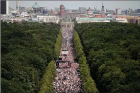  ??  ?? People gather at the Brandenbur­g Gate during Saturday’s protest in Berlin.
(AP/Markus Schreiber)