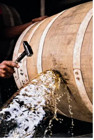  ??  ?? TOP, LEFT TO RIGHT Just a splash: emptying barrels to blend rum for bottling, at Distilleri­e J.M; EN HAUT, DE GAUCHE À DROITE L’alcool coule à flot quand c’est le temps de vider les fûts pour l’assemblage à la Distilleri­e J.M ;