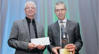  ??  ?? Denis Morin, 1er vice-président des Producteur­s de lait du Québec, présente le prix Lait’xcellent Or 2016 à Denis Desfossés.