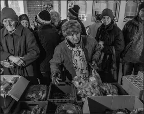  ?? FINBARR O’REILLY / THE NEW YORK TIMES ?? People collect aid Jan. 5 in Chasiv Yar, a frontline town in the Donetsk region of eastern Ukraine. The government says it can juggle its finances for a few months, but warns of an economic crisis if Western assistance remains stuck.