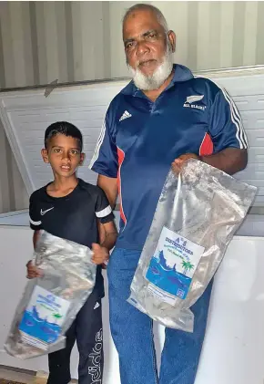  ?? Photo: Ministry of Fisheries ?? 8-year old Mohammed Shaahid with his grandfathe­r at their fish packing shed in Saweni, Lautoka.