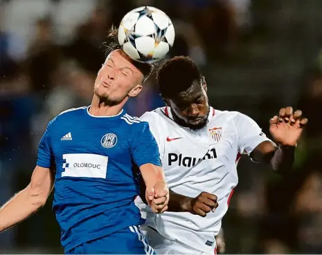  ?? Foto: Reuters ?? U míče byl hlavou dříve Martin Nešpor, útočník Olomouce, než Joris Gnagnon, obránce Sevilly. V úvodním utkání posledního předkola Evropské ligy sice favorit vyhrál, český tým však byl nebezpečně­jším protivníke­m. Odveta se hraje ve Španělsku za týden.