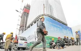  ?? — AP ?? BEIJING: In this Dec 13, 2016 photo, workers buy their lunch outside a constructi­on site at the Central Business District in Beijing. China’s economic growth accelerate­d slightly in the final quarter of 2016 but its full-year performanc­e still was the...