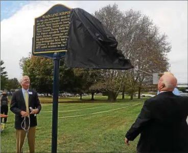  ?? PETE BANNAN – DIGITAL FIRST MEDIA ?? Anthony Morris and Daniel Kurkjian unveil the new Main Line Airport historical marker in the Great Valley Corporate Center Thursday. The marker honors the important history of the air field.