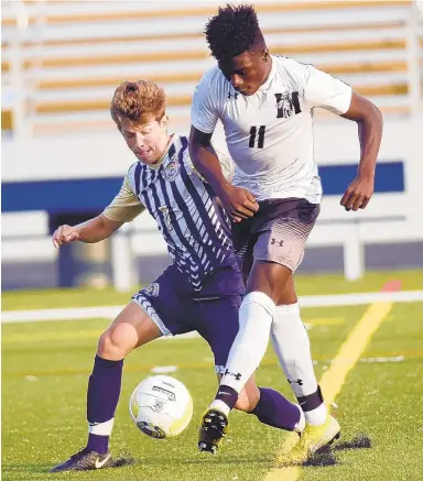  ?? BRIAN KRISTA/FOR CAPITAL GAZETTE ?? Meade's Tosin Ayokunle, right, makes a play on the ball while holding off pressure by Severna Park's Evan Blamphin during a boys soccer game at Severna Park High School on Thursday.