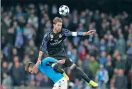  ?? ANDREW MEDICHINI / AP ?? Real Madrid’s Sergio Ramos collides with Napoli’s Nikola Maksimovic during their Champions League last-16, second-leg match at San Paolo stadium in Naples on Tuesday. Real won 3-1 to advance 6-2 on aggregate.