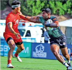  ?? – Picture courtesy Asia Rugby ?? Sri Lanka’s Tharinda Ratwatte tries to ward off a Chinese defender