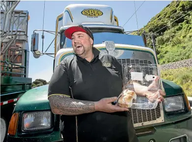  ?? ROSA WOODS/STUFF ?? Shannon Bulk Haulage truck driver Hayden Locke savours the cream doughnuts provided by the Salvation Army during yesterday’s highway closure north of Wellington.