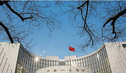  ?? — Reuters ?? Growth strategy: A Chinese national flag flies at the headquarte­rs of the PBOC in Beijing. With growth sliding to near 30-year lows and a partial trade deal with the United States proving elusive, China has slowly picked up its tempo of policy easing in recent weeks.