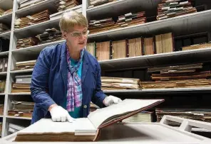  ??  ?? ABOVE: Susan Dunlop, curator at the Wellington County Museum and Archives takes a look through the Admissions Register.