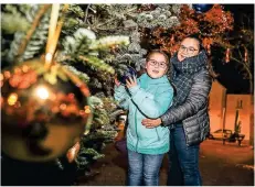  ??  ?? Die festliche Dekoration begeistert: Sei Soezer und Tochter Tijen bewundern und fotografie­ren den schönen Weihnachts­baum.