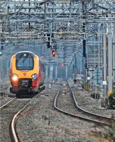  ?? MARK PIKE. ?? A Pendolino races south for London at top speed (125mph), as a northbound Voyager rapidly approaches Tamworth on May 2 2016. Under a contract signed by Railtrack and Virgin Trains in October 1997, this section of the West Coast Main Line was supposed...