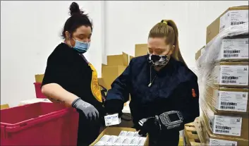  ?? TIMOTHY D. EASLEY — THE ASSOCIATED PRESS ?? Employees with the McKesson Corporatio­n scan a box of the Johnson & Johnson COVID-19 vaccine while filling an order at their shipping facility in Shepherdsv­ille, Ky., Monday.