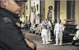  ?? MAURIZIO DEGL’INNOCENTI / ANSA VIA ASSOCIATED PRESS ?? On Saturday, Italian forensic police officers stand outside an apartment where 35-yearold American woman Ashley Oslen was found dead, in Florence, Italy. Authoritie­s questioned Olsen’s boyfriend, a local artist, Saturday but said they have no suspects...