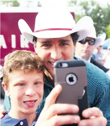  ??  ?? Justin Trudeau poses for a selfie during a pancake breakfast at Marda Loop Community Associatio­n on Saturday.